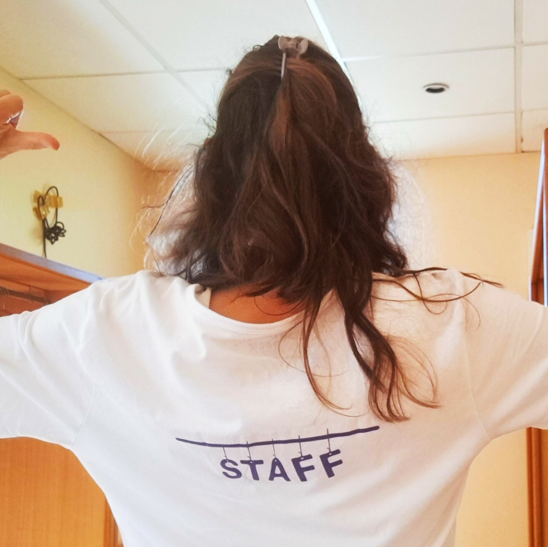 Folk&Curious : staff événementiel et coordination. Membre de l'équipe de dos portant un t-shirt "STAFF" lors d'un événement.