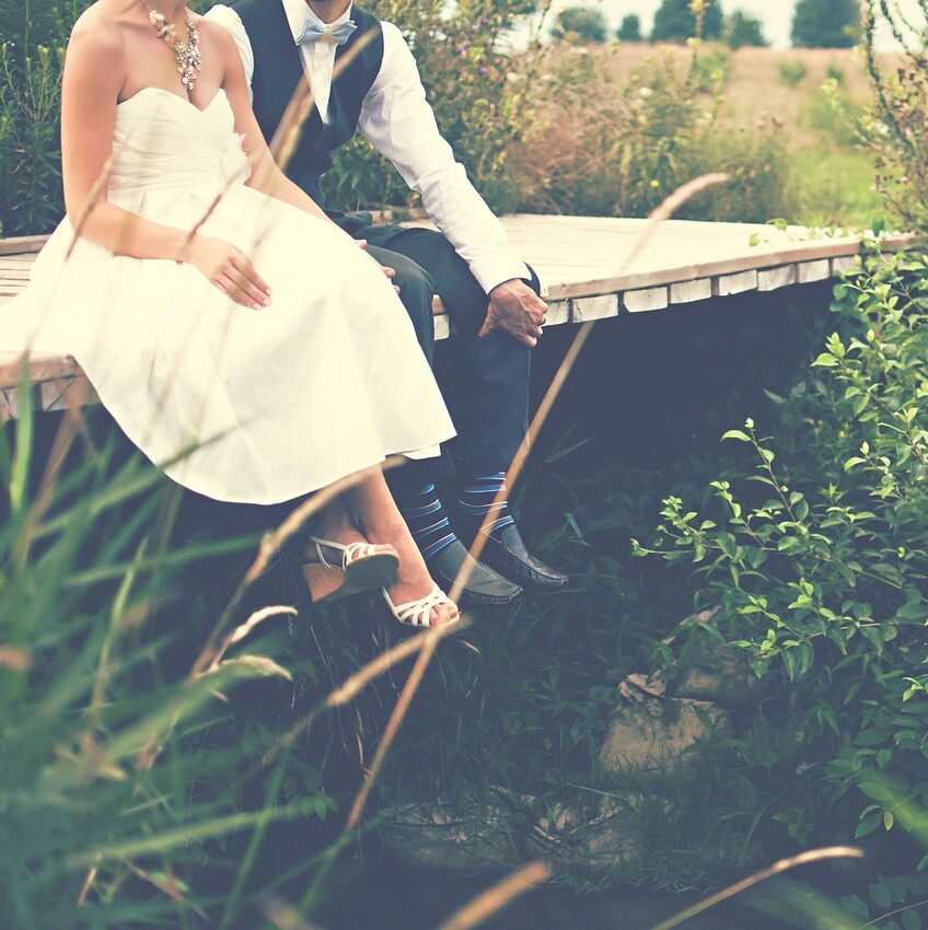 Mariage champêtre en extérieur – couple de mariés sur un ponton en bois, décoration naturelle et ambiance bohème, organisation par Folk&Curious Événements.