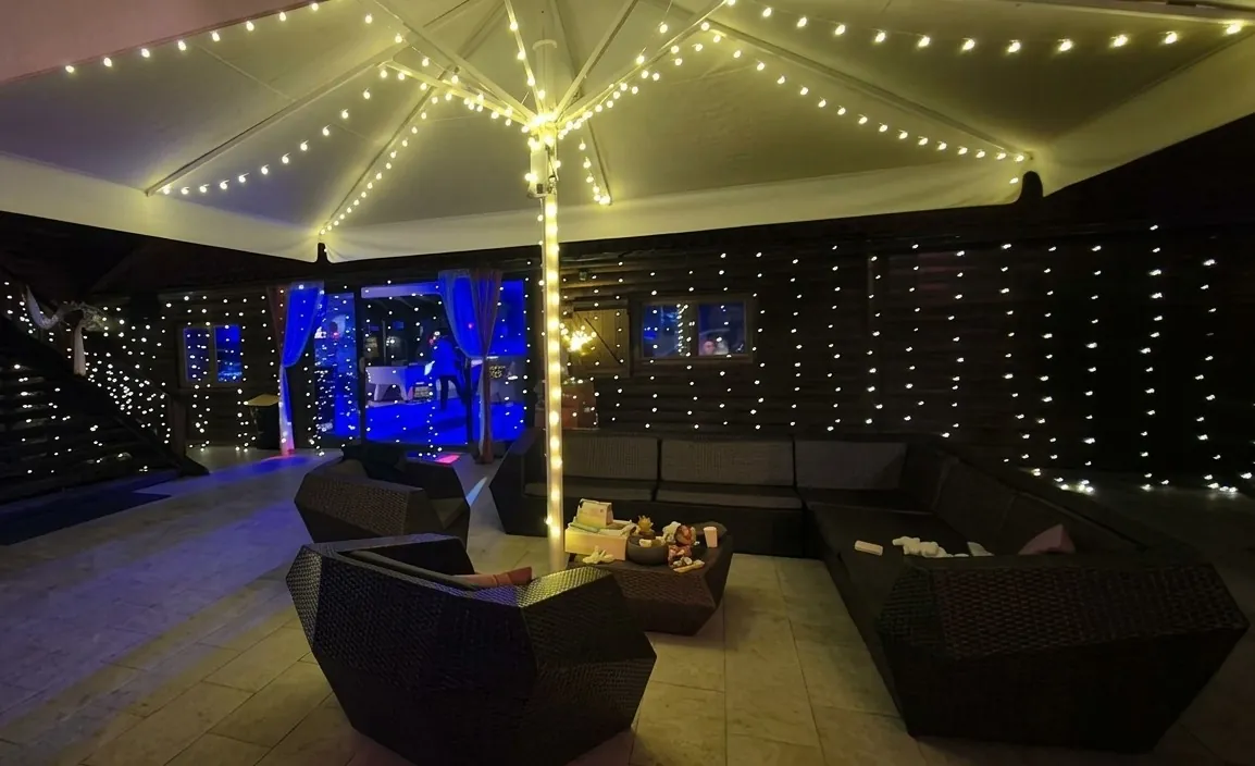 Espace lounge décoré de guirlandes lumineuses pour une soirée